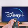 Hand en afstandsbediening met scherm Disney+